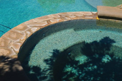 a picture of a spa next to a clean swimming pool. This pool company cleans spas and pools